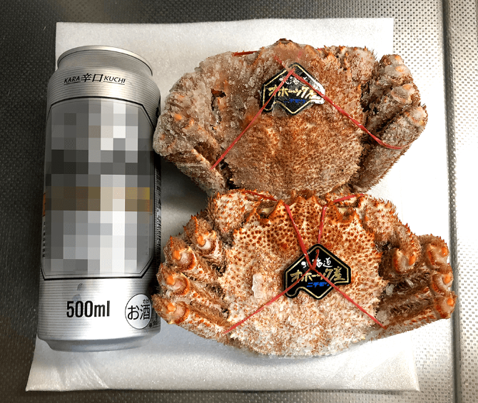 北海道紋別浜茹で 毛がに姿2杯（約900g）8,900円（税込）をビール缶と並べて大きさ比較
